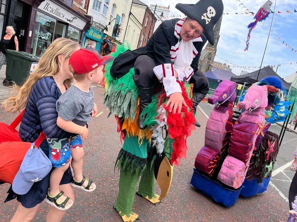 A costumed street performer meeting young visitors on Front Street at a previous Mouth of the Tyne Festival